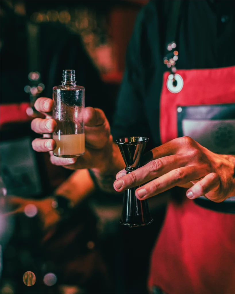 Bartender che misura gli ingredienti per preparare un cocktail al La Diosa.